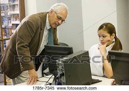 Teacher engaged in discussion with student in a computer lab View Large Photo Image Stock Photography - Teacher engaged in discussion with student in a computer lab. Fotosearch