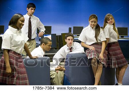 Teenage boy and girl students wearing uniforms sitting together in the computer lab View Large Photo Image Picture - Teenage boy and girl students wearing uniforms sitting together in the computer lab. Fotosearch