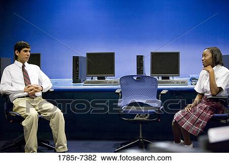 Teenage boy and girl students wearing uniforms sitting in a computer lab View Large Photo Image Stock Image - Teenage boy and girl students wearing uniforms sitting in a computer lab. Fotosearch
