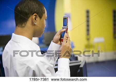 Teenage boy using mobile phone in the computer lab View Large Photo Image Stock Image - Teenage boy using mobile phone in the computer lab. Fotosearch