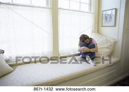 Teenage girl sitting on a couch View Large Photo Image Stock Image - Teenage girl sitting on a couch. Fotosearch
