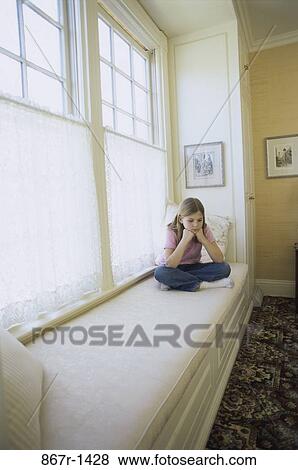 Teenage girl sitting on a sofa View Large Photo Image Stock Photo - Teenage girl sitting on a sofa. Fotosearch