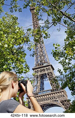 Stock Photo - Teenage girl taking pictures of a tower, Eiffel Tower, Paris, Ile-de-France, France. Fotosearch