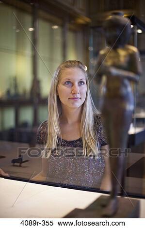 Stock Photography - Teenage girl watching Egyptian relics in a museum, Paris, Ile-de-France, France. Fotosearch