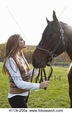 Teenage girl with horse on field View Large Photo Image Stock Image - Teenage girl with horse on field. Fotosearch