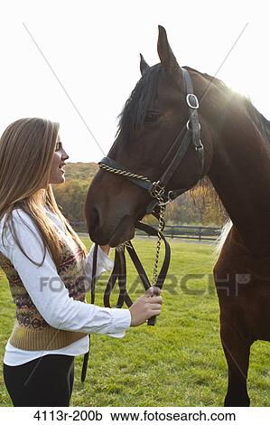 Teenage girl with horse on field View Large Photo Image Stock Image - Teenage girl with horse on field. Fotosearch