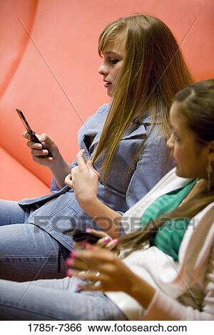Teenage girls with their cell phones View Large Photo Image Stock Photograph - Teenage girls with their cell phones. Fotosearch