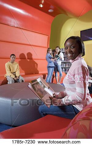 Teenagers hanging out in school library View Large Photo Image Stock Image - Teenagers hanging out in school library. Fotosearch