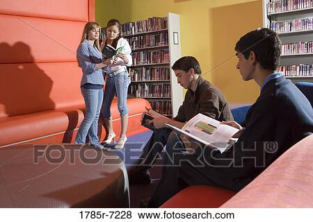 Teenagers hanging out in school library View Large Photo Image Stock Photo - Teenagers hanging out in school library. Fotosearch