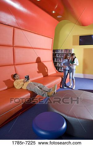 Teenagers hanging out in school library View Large Photo Image Stock Photography - Teenagers hanging out in school library. Fotosearch