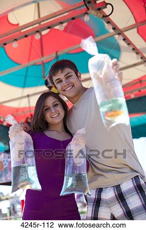 Teenagers showing off goldfish won at the fair View Large Photo Image Stock Image - Teenagers showing off goldfish won at the fair. Fotosearch