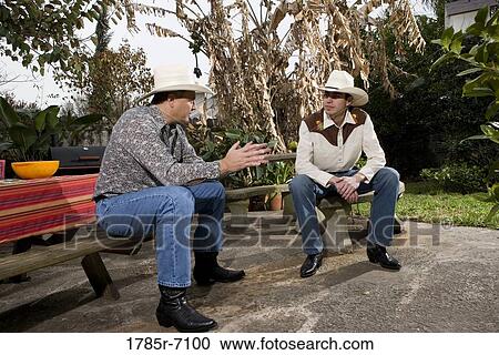 Tex-Mex father and son engaged in conversation in the backyard of their house View Large Photo Image Stock Image - Tex-Mex father and son engaged in conversation in the backyard of their house. Fotosearch