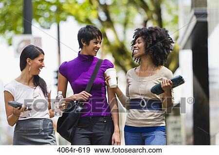 Three businesswomen walking in street downtown View Large Photo Image Stock Photo - Three businesswomen walking in street downtown. Fotosearch
