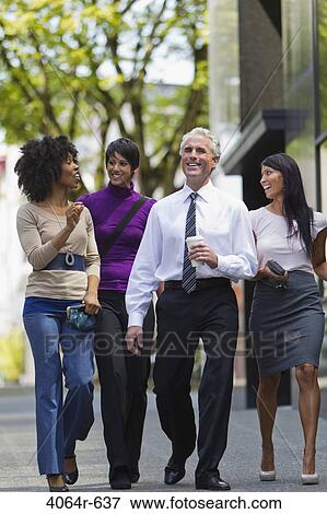 Stock Photo - Three businesswomen walking outside office with businessman. Fotosearch