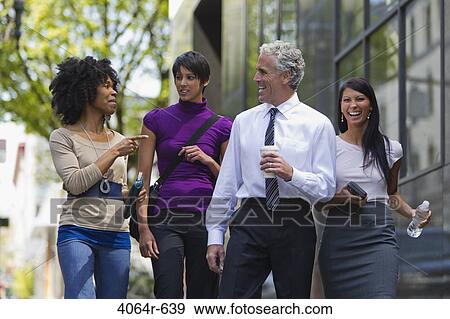 Three businesswomen walking outside office with businessman View Large Photo Image Stock Photo - Three businesswomen walking outside office with businessman. Fotosearch