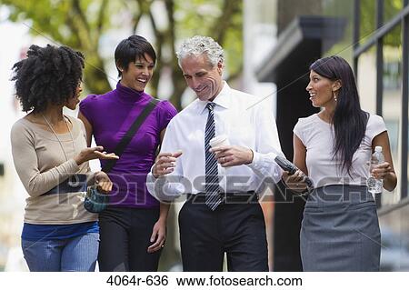 Stock Photograph - Three businesswomen walking outside office with businessman. Fotosearch