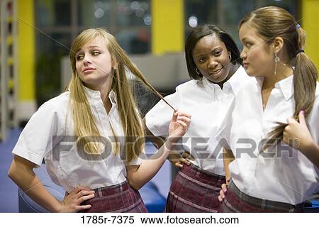 Three teenage girl students wearing uniforms hanging out in a library View Large Photo Image Stock Photography - Three teenage girl students wearing uniforms hanging out in a library. Fotosearch