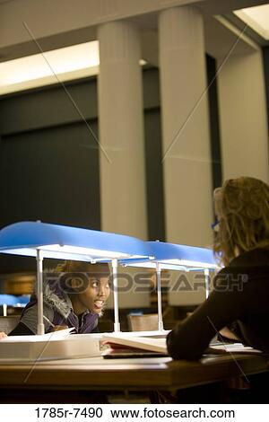Three young women studying in the reading room of a library View Large Photo Image Stock Image - Three young women studying in the reading room of a library. Fotosearch