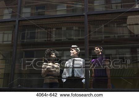 Two businesswomen looking through office window with businessman View Large Photo Image Stock Image - Two businesswomen looking through office window with businessman. Fotosearch