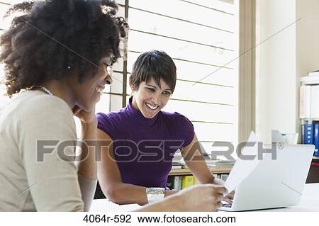 Two businesswomen working on project in office View Large Photo Image Stock Image - Two businesswomen working on project in office. Fotosearch