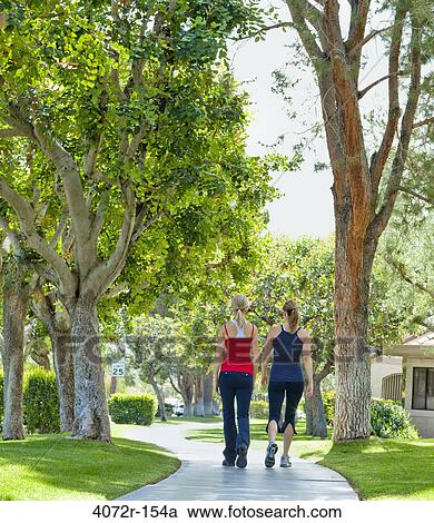 Two mature women walking in a park View Large Photo Image Stock Image - Two mature women walking in a park. Fotosearch