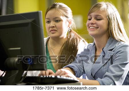 Two teenage girls using a computer View Large Photo Image Stock Image - Two teenage girls using a computer. Fotosearch
