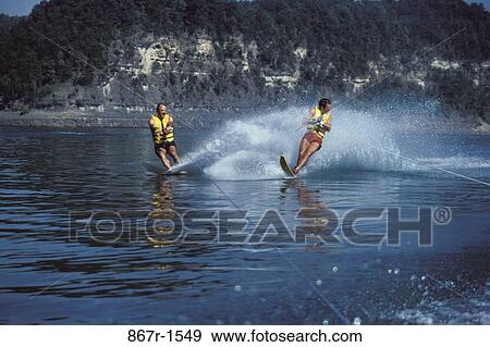 Two young men water skiing View Large Photo Image Stock Photo - Two young men water skiing. Fotosearch