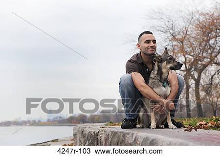 USA, Chicago, Lake Michigan, smiling man hugging dog on ledge View Large Photo Image Stock Image - USA, Chicago, Lake Michigan, smiling man hugging dog on ledge. Fotosearch