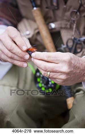 Stock Photo - USA, Washington, Vancouver, Close-up of fisherman's hands tying fly onto line. Fotosearch