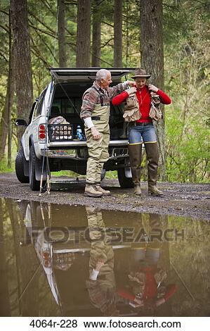 Stock Photo - USA, Washington, Vancouver, Couple getting ready for fishing next to car. Fotosearch