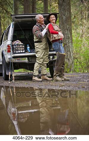 Stock Photo - USA, Washington, Vancouver, Couple getting ready for fishing next to car. Fotosearch