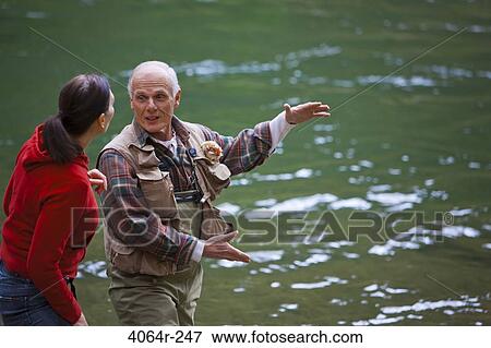 Stock Photo - USA, Washington, Vancouver, Couple talking by river. Fotosearch