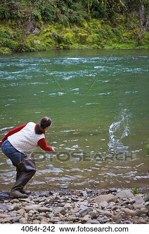 USA, Washington, Vancouver, Rear view of woman skipping stones on river View Large Photo Image Stock Image - USA, Washington, Vancouver, Rear view of woman skipping stones on river. Fotosearch