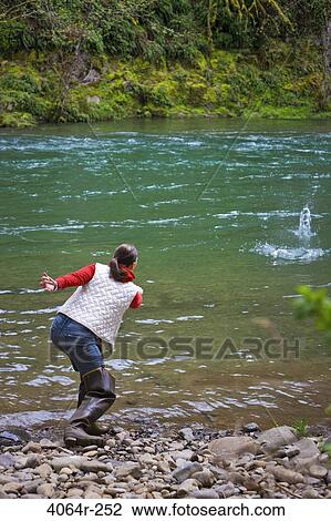 USA, Washington, Vancouver, Rear view of woman skipping stones on river View Large Photo Image Stock Image - USA, Washington, Vancouver, Rear view of woman skipping stones on river. Fotosearch