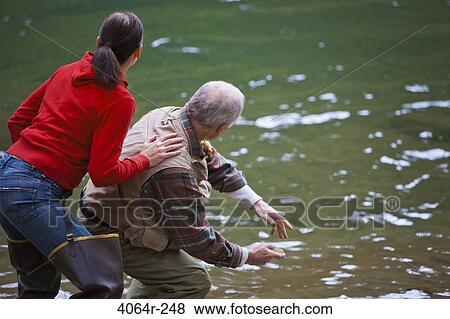 USA, Washington, Vancouver, Rear view of couple skipping stones on river View Large Photo Image Stock Photo - USA, Washington, Vancouver, Rear view of couple skipping stones on river. Fotosearch