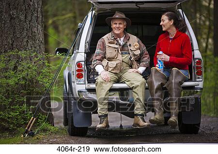 USA, Washington, Vancouver, Smiling couple sitting in back of car after fishing View Large Photo Image Stock Photo - USA, Washington, Vancouver, Smiling couple sitting in back of car after fishing. Fotosearch