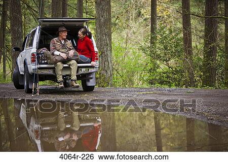 USA, Washington, Vancouver, Smiling couple sitting in back of car after fishing View Large Photo Image Stock Photograph - USA, Washington, Vancouver, Smiling couple sitting in back of car after fishing. Fotosearch