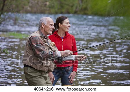 Stock Photograph - USA, Washington, Vancouver, Smiling couple fishing in river. Fotosearch