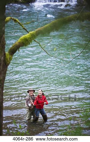 USA, Washington, Vancouver, Smiling couple fishing in river View Large Photo Image Stock Photograph - USA, Washington, Vancouver, Smiling couple fishing in river. Fotosearch