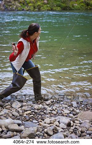 USA, Washington, Vancouver, Woman skipping stones in river View Large Photo Image Picture - USA, Washington, Vancouver, Woman skipping stones in river. Fotosearch