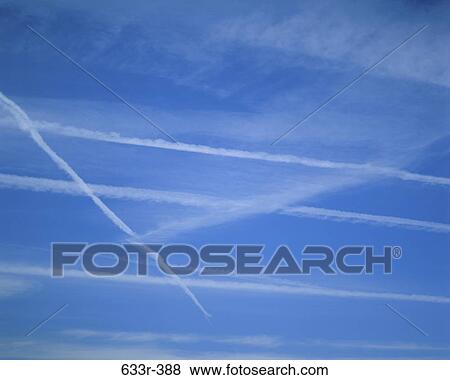 Vapor trail from jets in a blue sky View Large Photo Image Stock Photo - Vapor trail from jets in a blue sky. Fotosearch