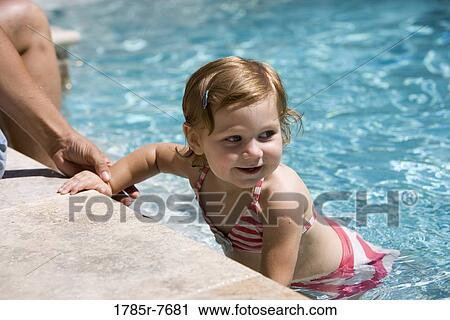 View of a baby girl playing in a swimming pool View Large Photo Image Stock Image - View of a baby girl playing in a swimming pool. Fotosearch