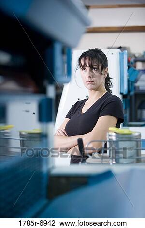 View of a blue-collar woman standing behind some machinery View Large Photo Image Stock Image - View of a blue-collar woman standing behind some machinery. Fotosearch
