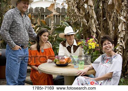 View of a smiling Tex-Mex family at a round patio table View Large Photo Image Stock Photo - View of a smiling Tex-Mex family at a round patio table. Fotosearch