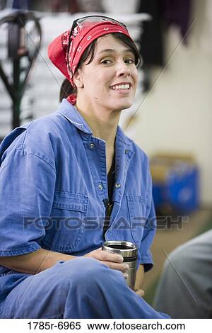 View of a woman in coveralls sitting down during a coffee break View Large Photo Image Stock Photography - View of a woman in coveralls sitting down during a coffee break. Fotosearch