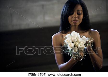 View of a young woman in a black dress holding a bouquet of white roses View Large Photo Image Stock Photo - View of a young woman in a black dress holding a bouquet of white roses. Fotosearch