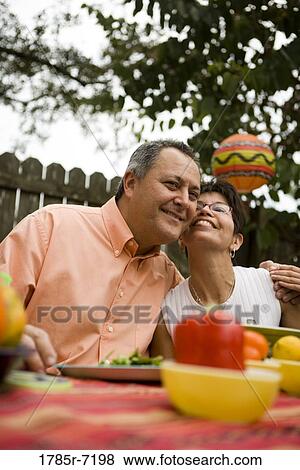 View of an affectionate mature couple at a picnic table in the backyard of their house View Large Photo Image Stock Photo - View of an affectionate mature couple at a picnic table in the backyard of their house. Fotosearch