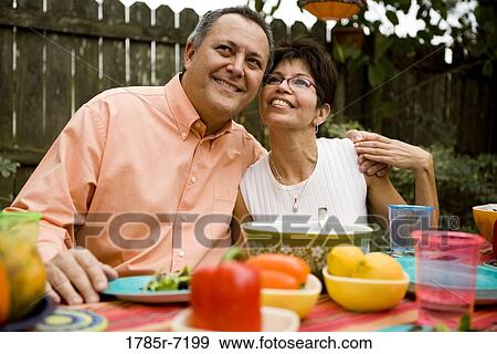 View of an affectionate mature couple at a picnic table in the backyard of their house View Large Photo Image Stock Photo - View of an affectionate mature couple at a picnic table in the backyard of their house. Fotosearch