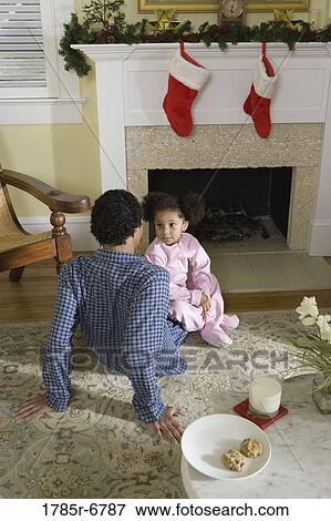 View of brother and sister sitting by fireplace decorated for Christmas, waiting for Santa View Large Photo Image Stock Photo - View of brother and sister sitting by fireplace decorated for Christmas, waiting for Santa. Fotosearch
