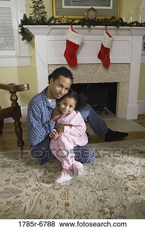 View of brother and sister sitting by fireplace decorated for Christmas, waiting for Santa View Large Photo Image Stock Photo - View of brother and sister sitting by fireplace decorated for Christmas, waiting for Santa. Fotosearch
